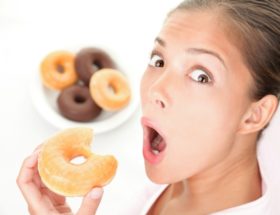 Femme surprise en train de manger un donut